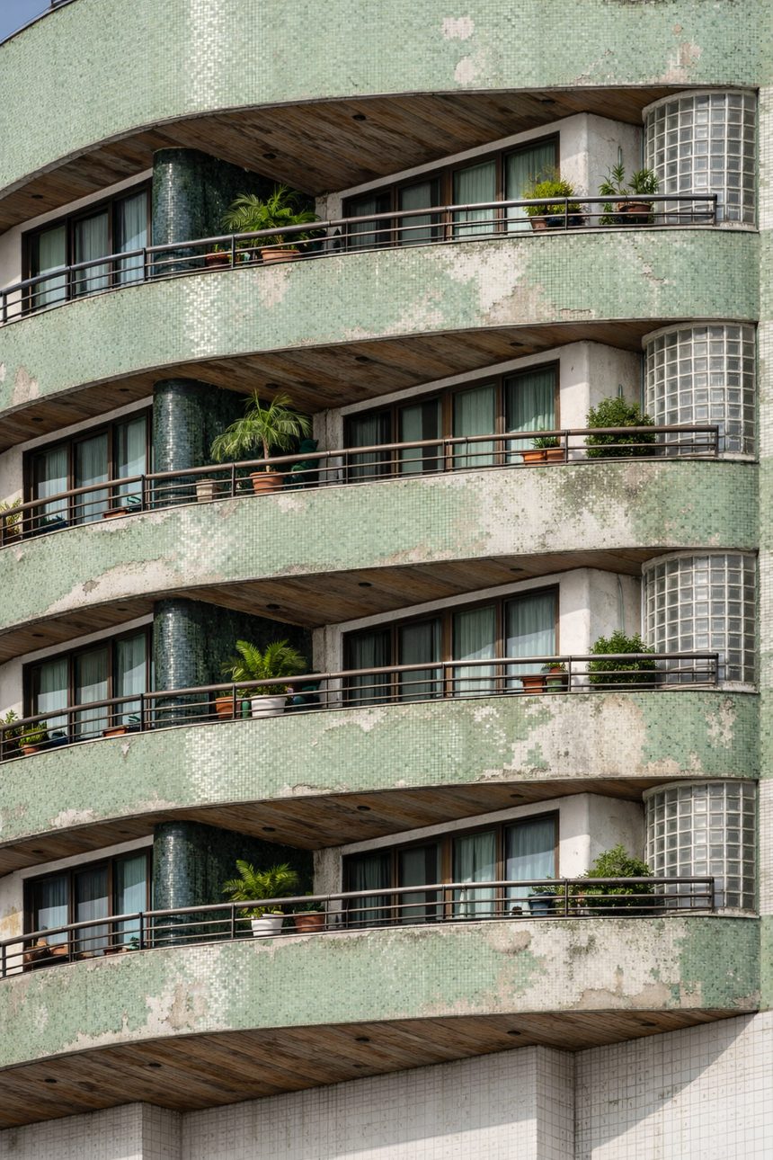 Fachada de condomínio desgastada, com mofo e manchas, antes da reforma